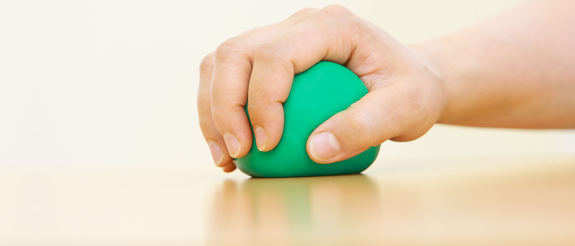 Eine Person übt mit einem grünen Ball das greifen
